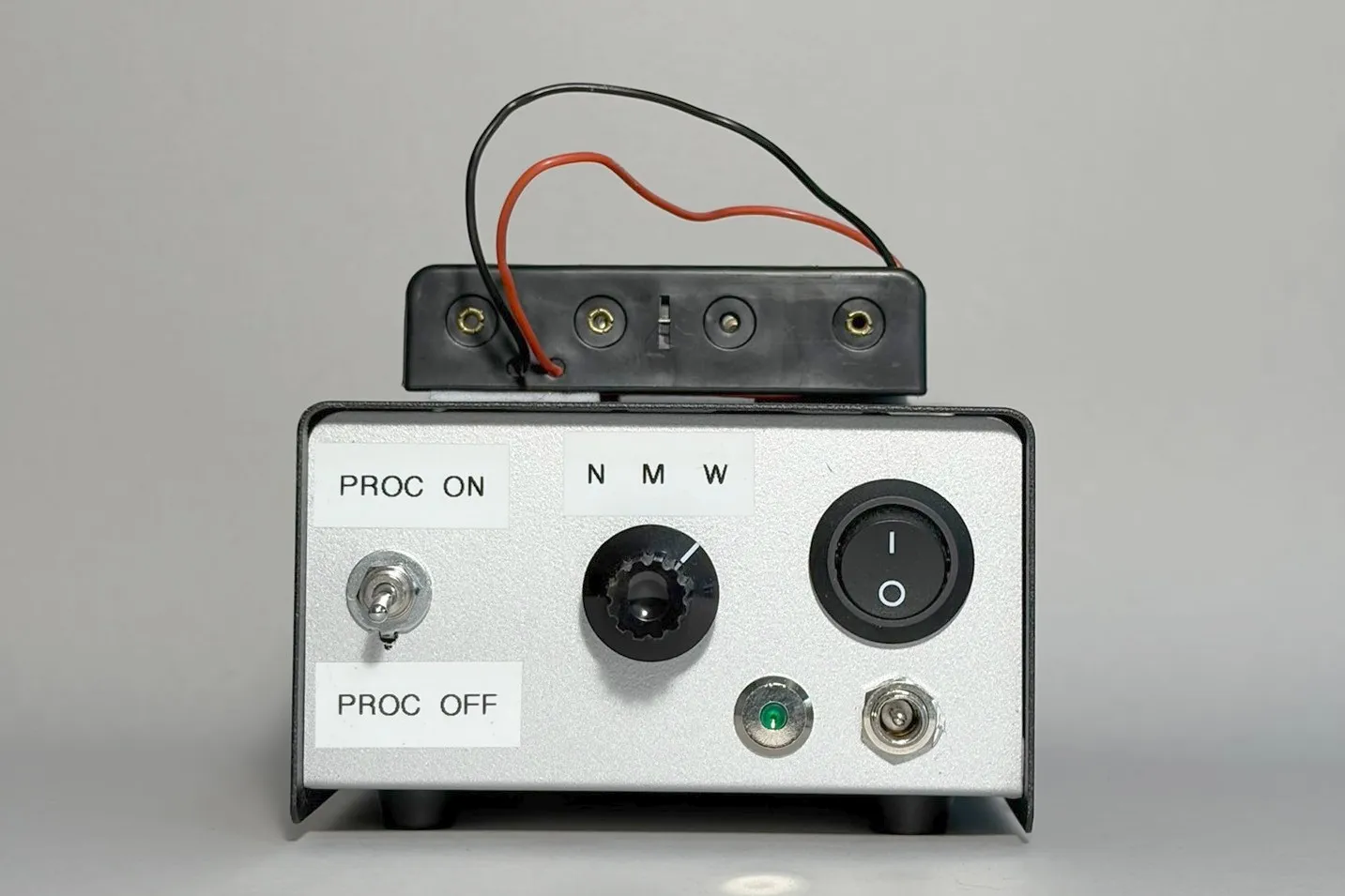 Drone payload in an off-the-shelf box, a four-cell 18650 holder taped to the lid, pickup pattern and processor switches on a hand-labelled front panel.